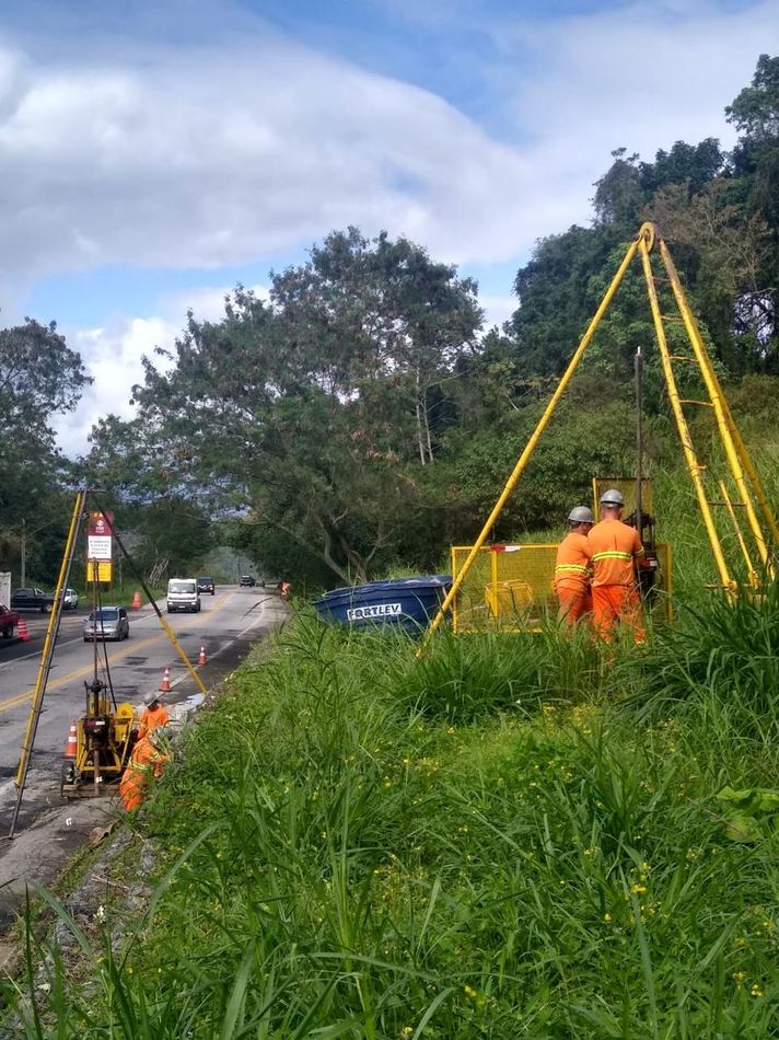 Equipe da Geoloc com tripé de sondagem em encosta de rodovia